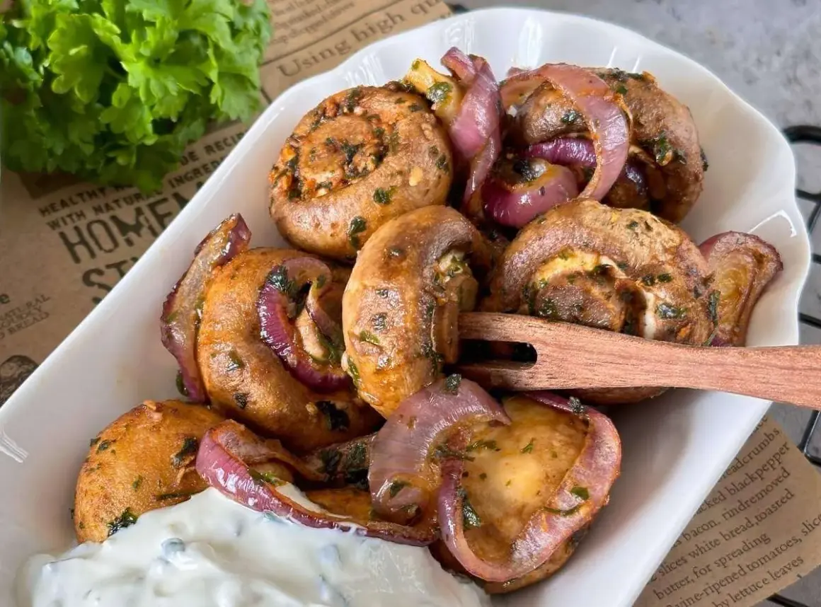 Gefüllte Champignons mit roten Zwiebeln, perfekt aus dem Airfryer, serviert mit Dip.