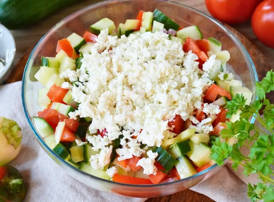 Frischer Schopska Salat mit Gurken, Tomaten und viel zerbröseltem Schafskäse, garniert mit Petersilie.