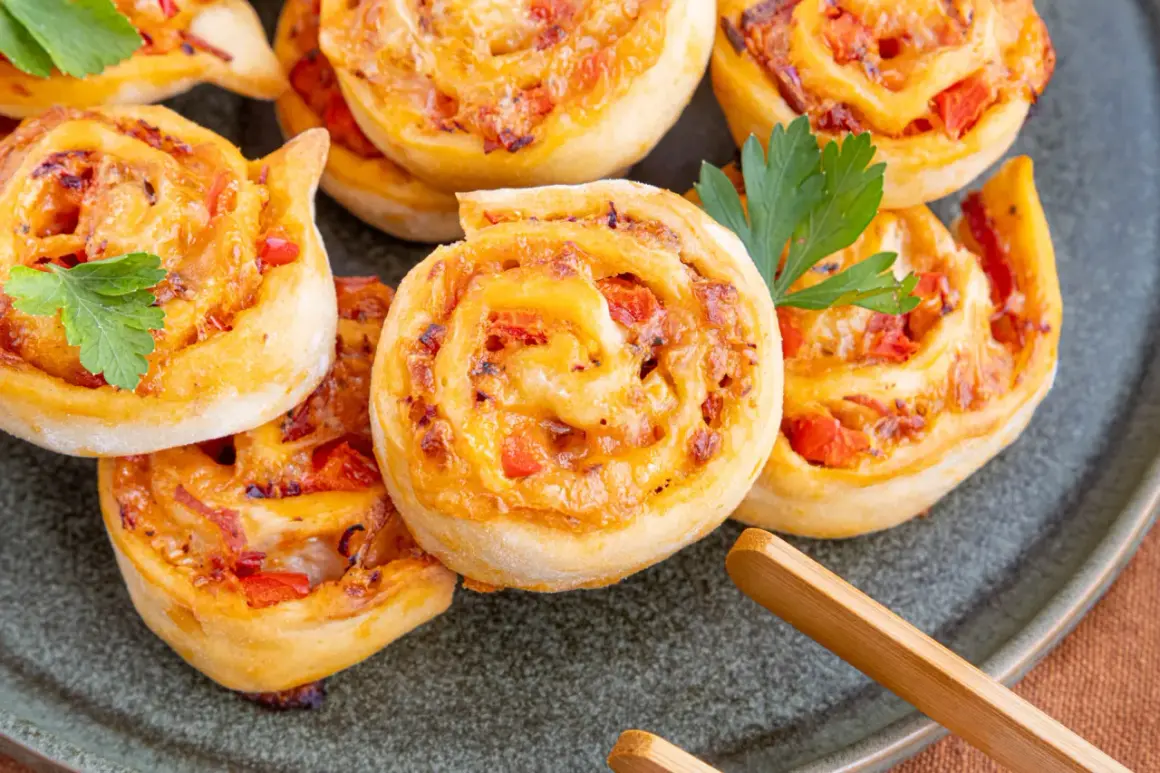 Goldbraune Pizzaschnecken mit Tomaten und Käse, garniert mit Petersilie. Ein leckeres Pizzaschnecken Rezept für jeden Anlass.