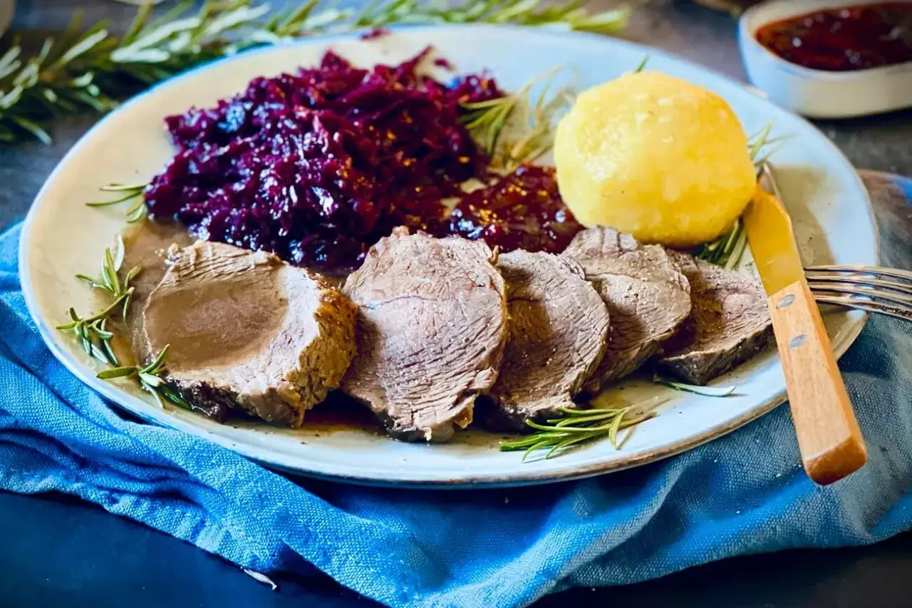 Saftiger Rinderbraten, serviert mit Rotkohl und Klößen. Ein köstliches Rinderbraten Rezept für ein festliches Essen.