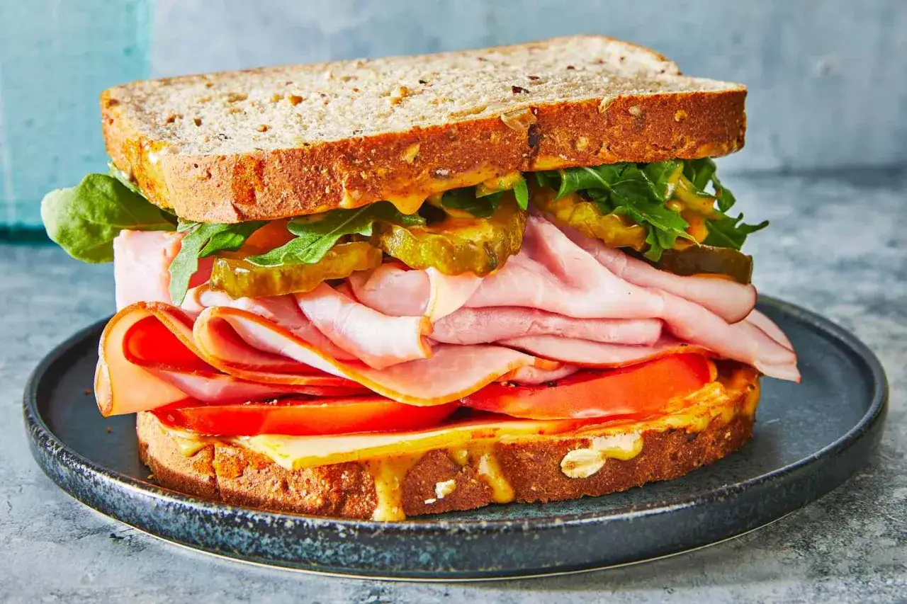 Herzhaft belegtes Sandwich mit Schinken, K&auml;se, Tomaten, Gurken und Rucola. Ein tolles Beispiel f&uuml;r leckere Sandwich Rezepte.