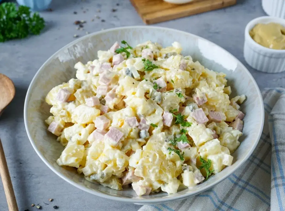 Omas Kartoffelsalat: cremiger Kartoffelsalat mit Würfelchen von Schinken und Ei, garniert mit Petersilie. Ein Klassiker, der immer schmeckt.