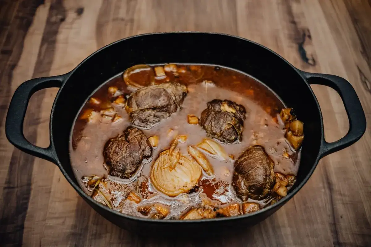 Herzhafte schmorgerichte im gusseisentopf, mit zarten Fleischr&ouml;llchen und Wurzelgem&uuml;se in einer dunklen Sauce.