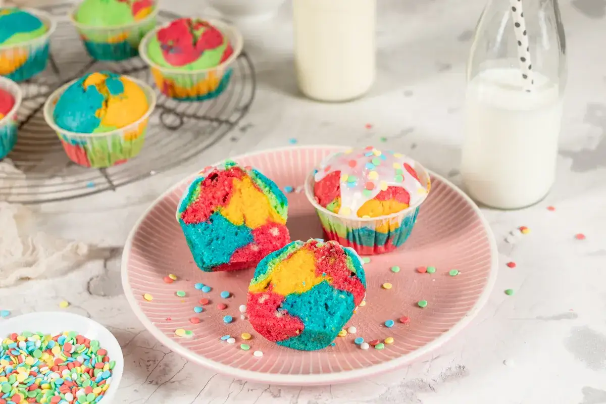 Bunte Muffins mit Zuckerguss und Streuseln, perfekt für einen Kindergeburtstag.