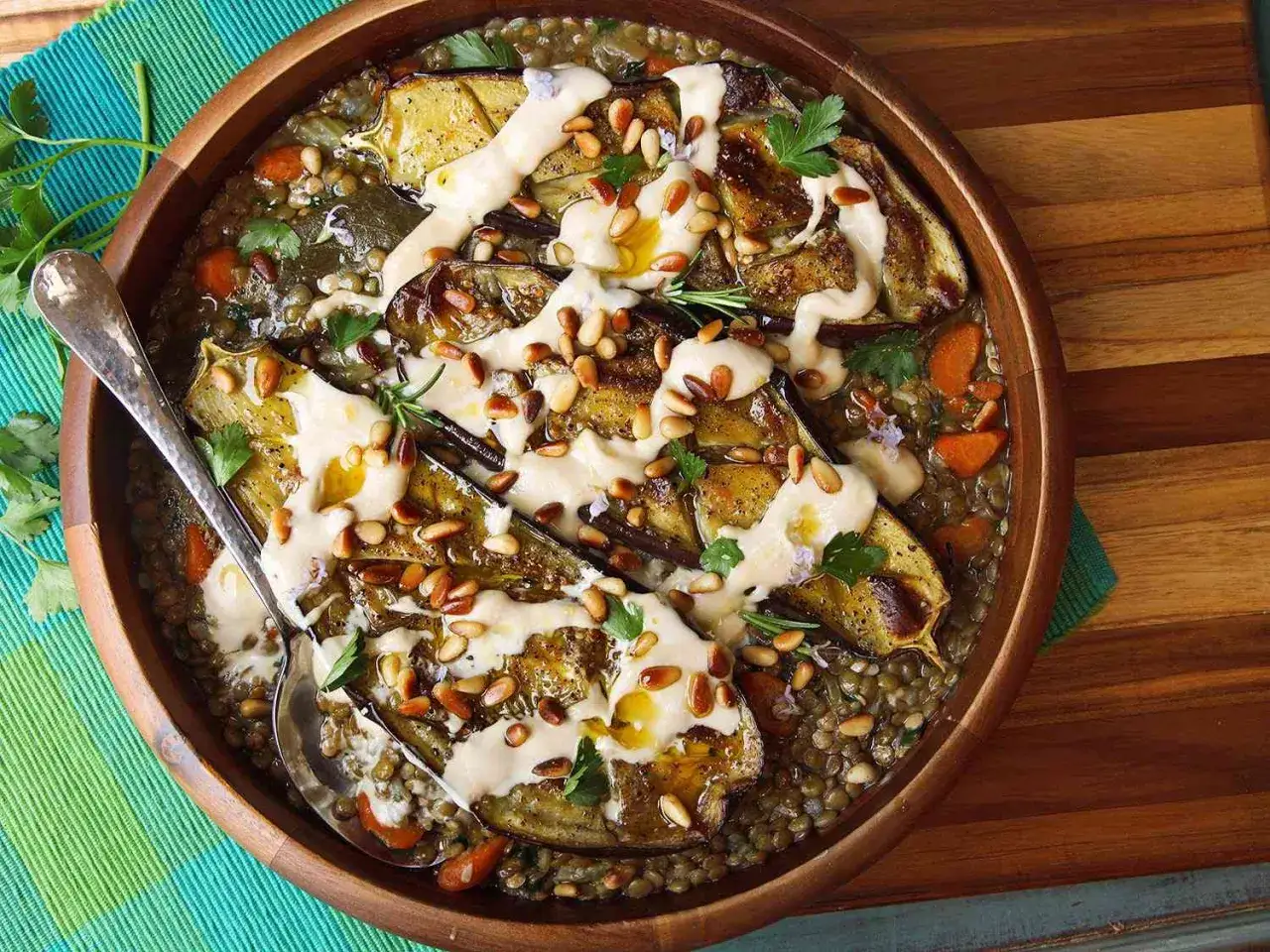 Herzhafte Linsen mit im Ofen gebackenen Auberginen, garniert mit Pinienkernen und Tahini-Dressing. Ein k&ouml;stliches Gericht, das Lust auf mehr macht.