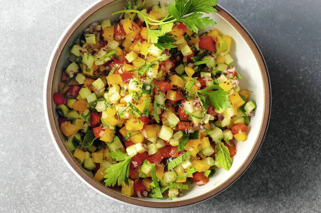 Frischer Paprika Salat mit Gurken, Tomaten und Kr&auml;utern, garniert mit Petersilie.