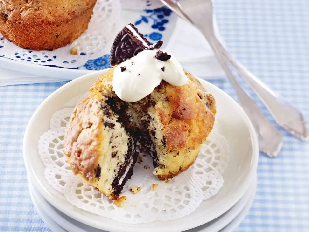 Ein aufgeschnittener Oreo Muffin mit Sahne und einem Oreo-St&uuml;ck obendrauf.