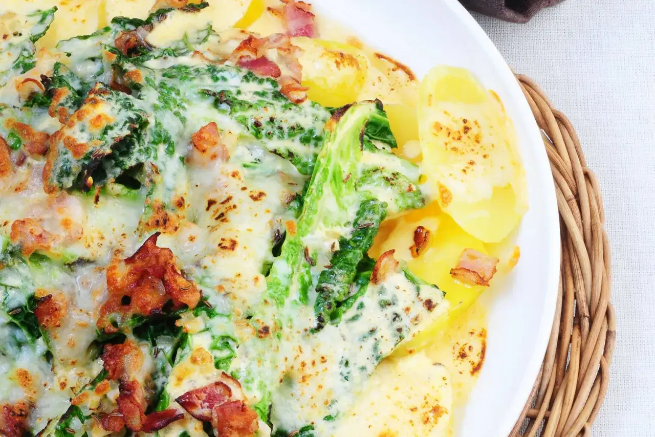 Herzhafte Auflauf-Idee: Grünkohl mit Kartoffeln und Speck, überbacken mit Käse. Perfekt für wirsing rezepte.