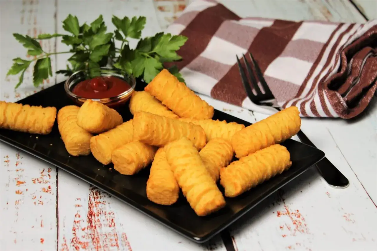 Goldbraune Kroketten, frisch zubereitet, liegen auf einem schwarzen Teller mit Ketchup und Petersilie. Perfekt zum Selbermachen!