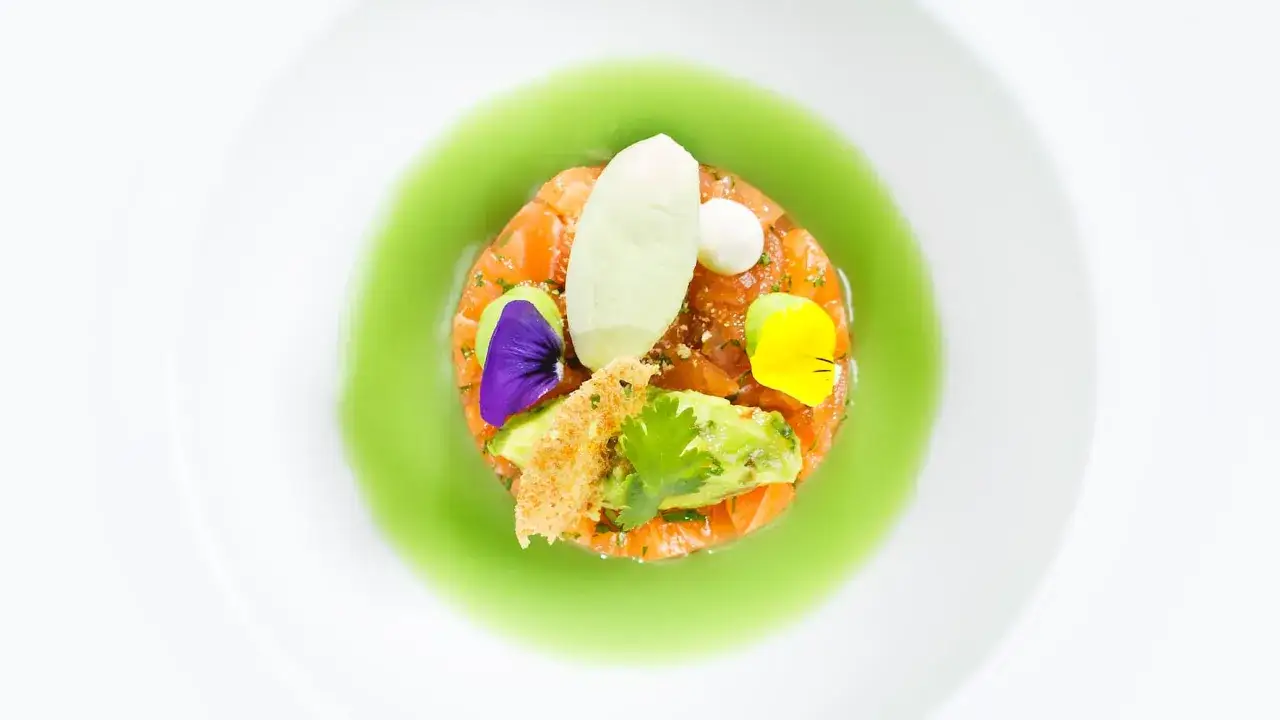 Sternek&uuml;che: Lachstatar mit Avocado, garniert mit Bl&uuml;ten und einer gr&uuml;nen Sauce. Ein Kunstwerk auf dem Teller.