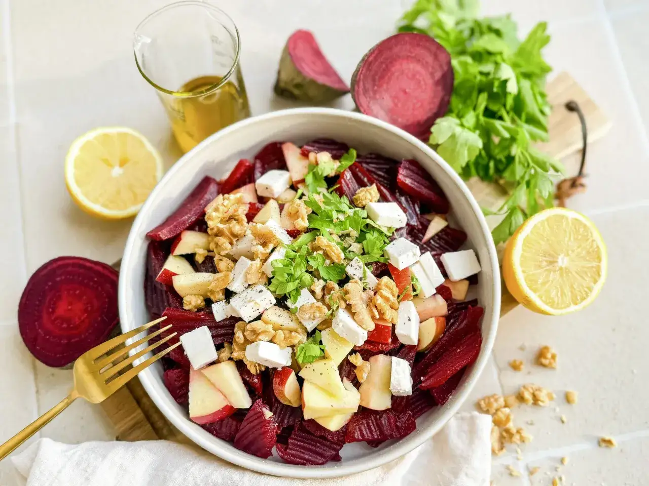 Ein bunter rote beete salat mit Apfelst&uuml;cken, Feta, Waln&uuml;ssen und frischer Petersilie, garniert mit Zitronenspalten.