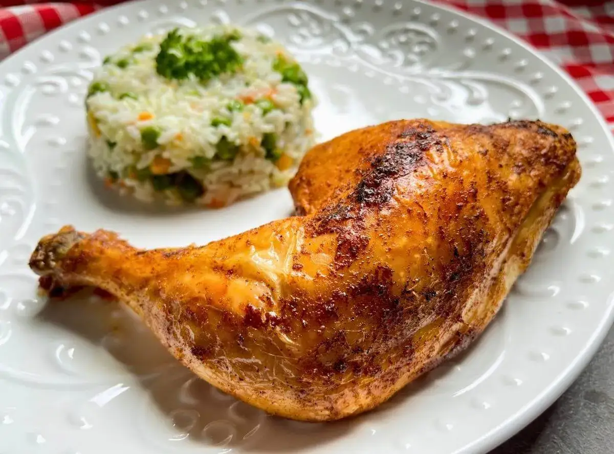Ein knuspriges pollo fino mit Reis und Erbsen auf einem wei&szlig;en Teller.