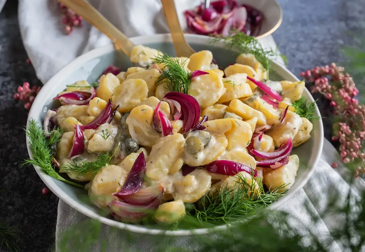 Cremiger Kartoffelsalat mit roten Zwiebeln und Dill, verfeinert mit einem Hauch Balsamico. Ein Genuss für jeden Anlass.