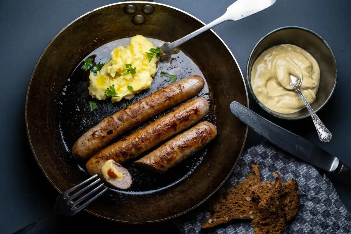 Gebratene Bratwurst mit Kartoffelbrei und Senf, ein Klassiker der Bratwurst Rezepte.