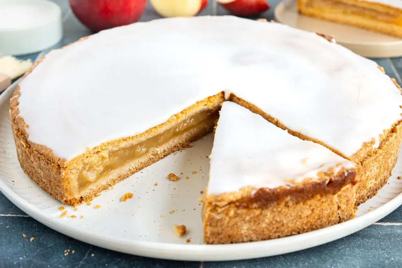 Ein köstlicher Apfelkuchen mit einer süßen Apfelmusfüllung, bedeckt mit glasiertem Zuckerguss.
