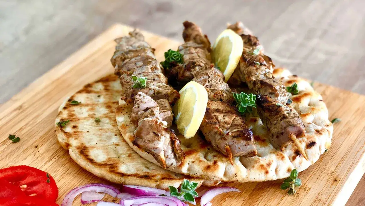 Saftige Souvlaki-Spie&szlig;e auf Fladenbrot, garniert mit Zitrone und Kr&auml;utern. Ein k&ouml;stliches Souvlaki Rezept zum Nachmachen.
