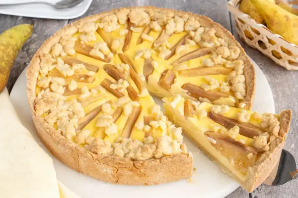 Ein köstlicher birnenkuchen mit pudding und Streuseln, bereit zum Servieren.