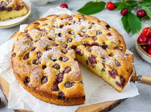 Saftiger Kirschkuchen, perfekt für das Kirschkuchen Rezept. Mit Puderzucker bestäubt und voller Kirschen.