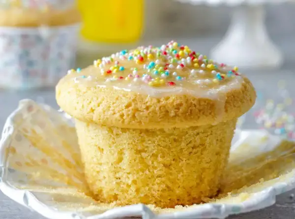 Ein leckerer Muffin mit Zuckerguss und bunten Streuseln, perfekt für einen Kindergeburtstag.