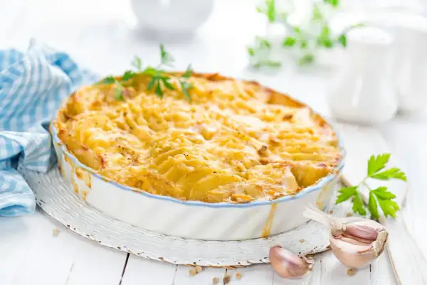 Kretanische Kartoffeln, goldbraun gebacken in einer Auflaufform, mit Knoblauch und Petersilie garniert. Ein Genuss!