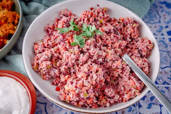 Bunter Karottensalat, frisch zubereitet im Thermomix, garniert mit Petersilie. Daneben eine Schale mit Dip.