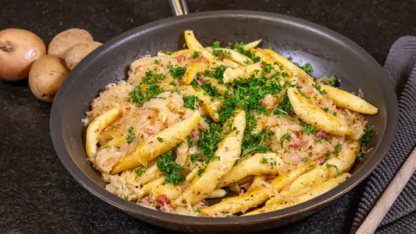 Herzhaftes Gericht mit Spätzle und Sauerkraut, garniert mit Petersilie. Ein tolles Sauerkraut Rezept für Genießer.