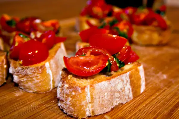 Frisch zubereitete Bruschetta mit Tomaten und Basilikum auf geröstetem Brot. Ein einfaches und leckeres bruschetta rezept.
